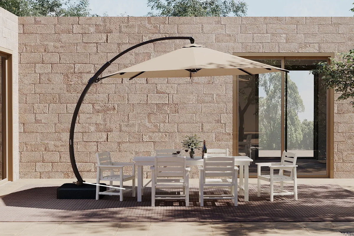 Outdoor patio set with a large umbrella and chairs in front of a stone wall.