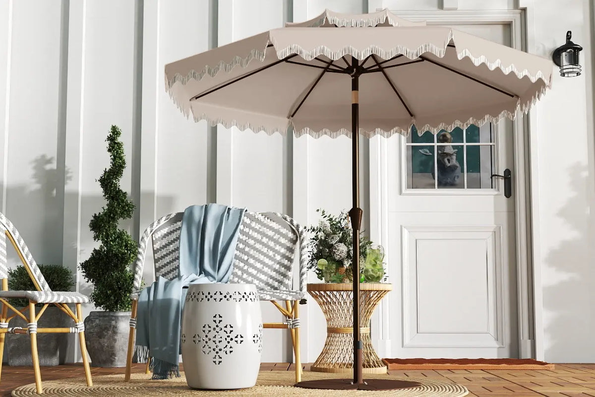 Beige patio umbrella with decorative trim on a wooden deck.