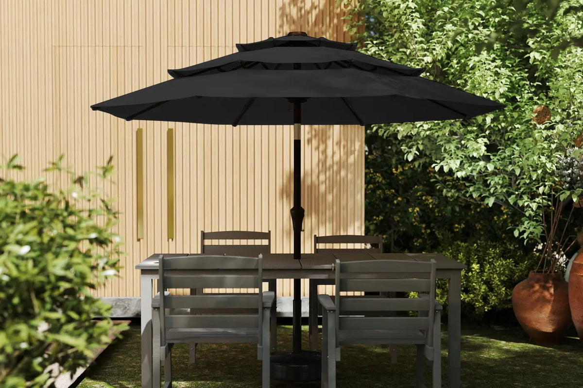 Outdoor furniture set with a black umbrella in a garden setting.
