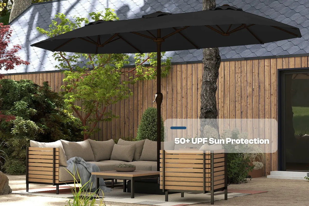 Outdoor patio set with a large black umbrella providing shade in a garden setting.