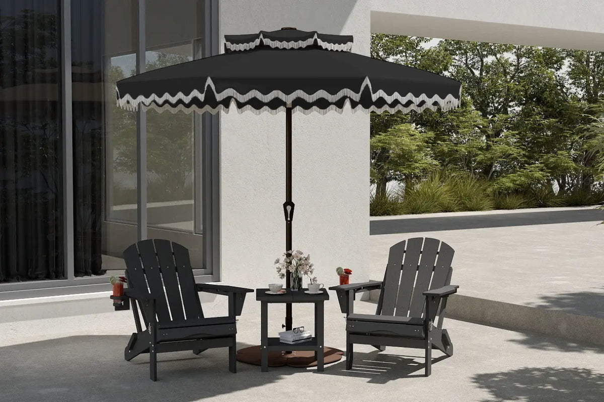 Outdoor patio set with two chairs and a small table under a large black umbrella with white trim, on a patio with trees in the background.