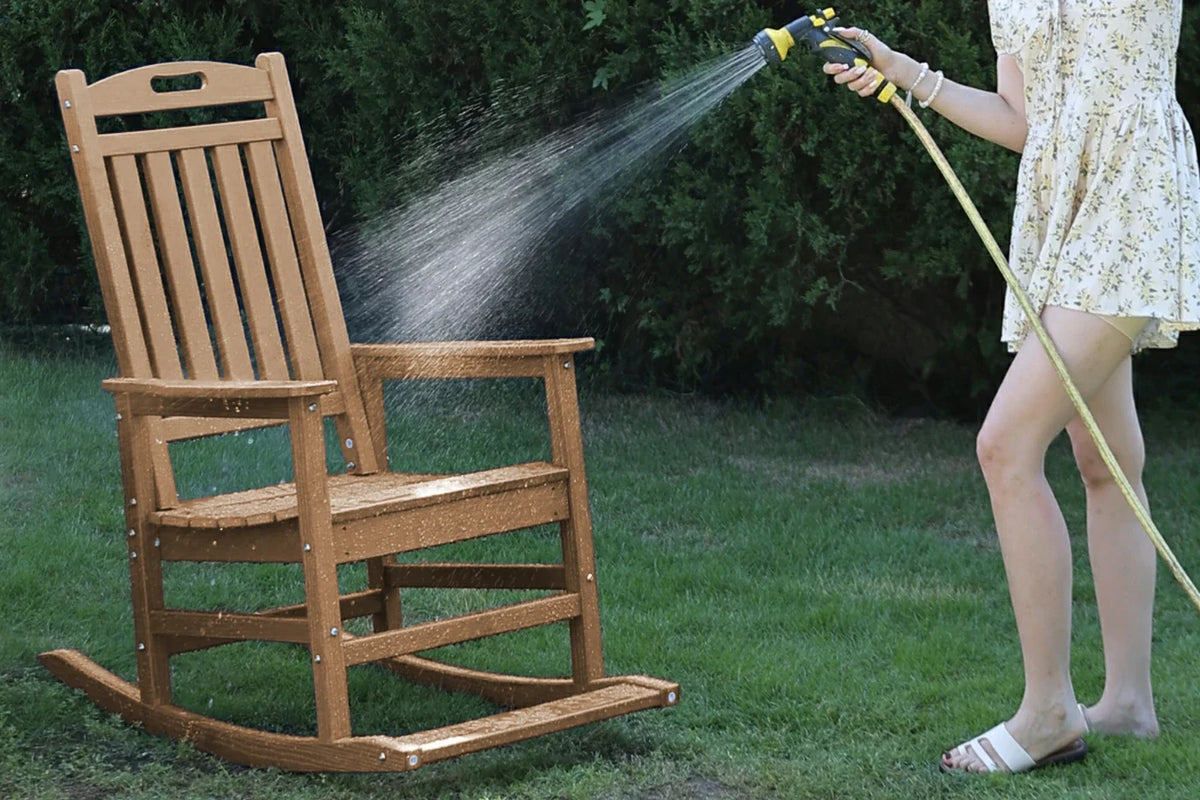 Wooden rocking chair being rinsed with a hose on a grassy area