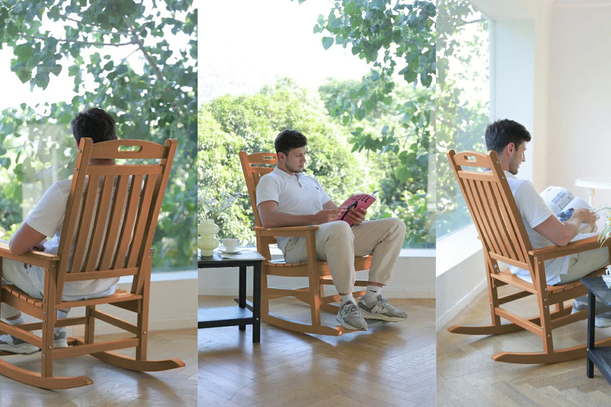 Man sitting in a wooden rocking chair in a bright room with large windows.