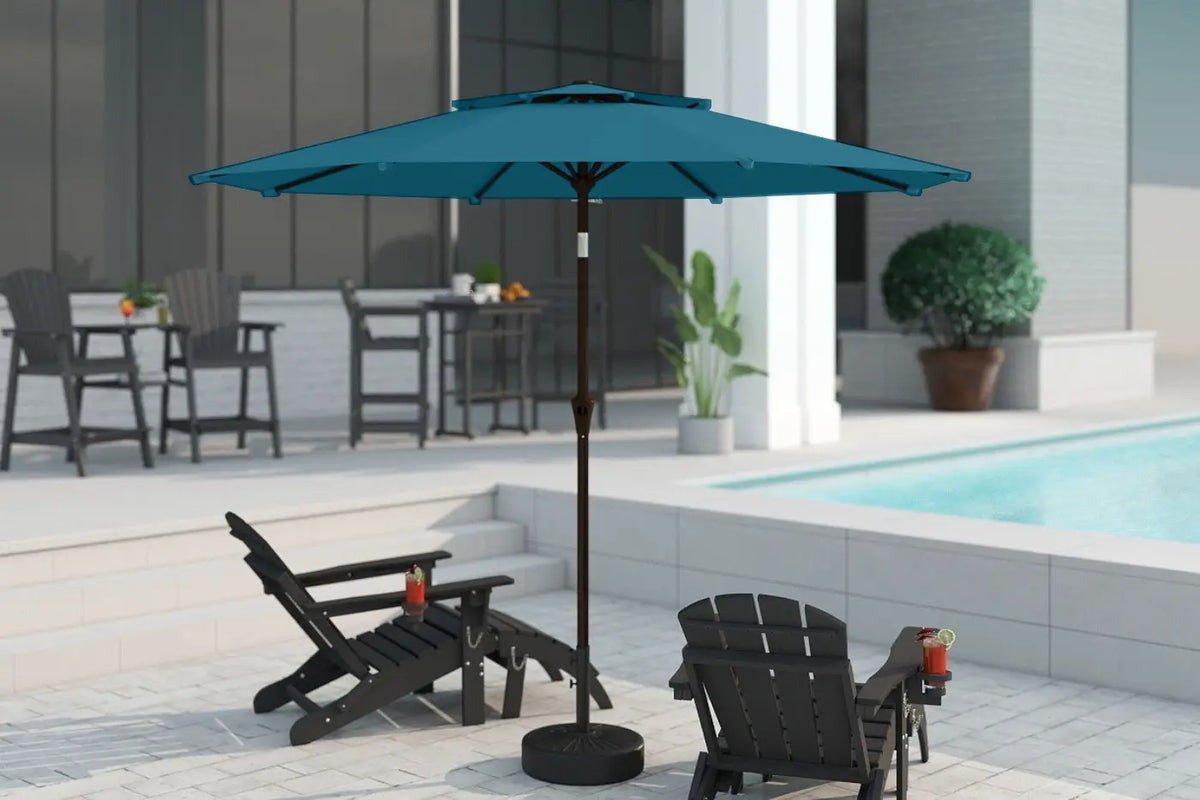 Blue patio umbrella on a stand in an outdoor setting with chairs and a pool.