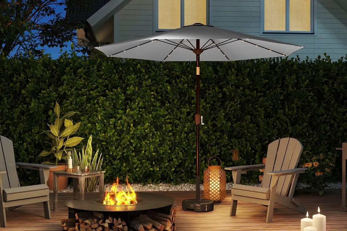 Outdoor patio setup with fire pit, chairs, and umbrella on a wooden deck.