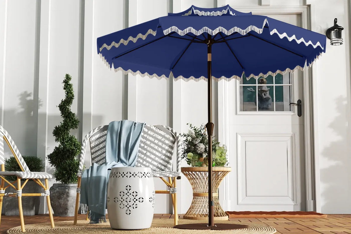 Blue outdoor umbrella with white trim on a patio with chairs and plants.