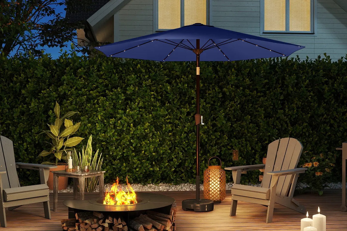 Outdoor patio scene with a fire pit, chairs, and a blue umbrella.