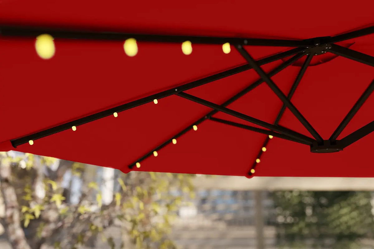 Red outdoor umbrella with string lights against a blurred background