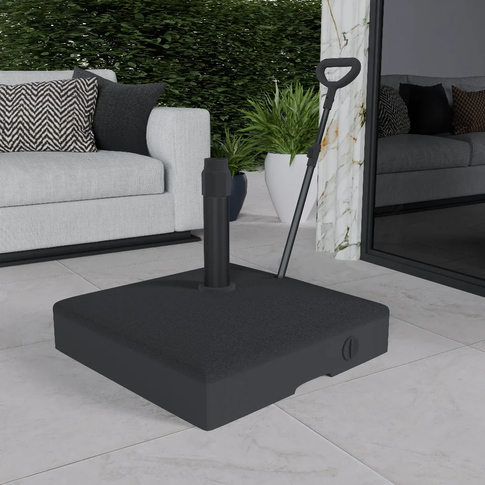 A black outdoor umbrella base with a handle, placed on a tiled floor, with a sofa and cushions in the background.