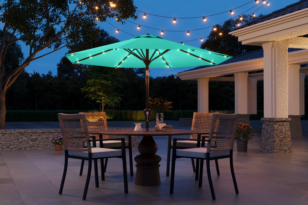 Outdoor patio set with illuminated umbrella and string lights at night.
