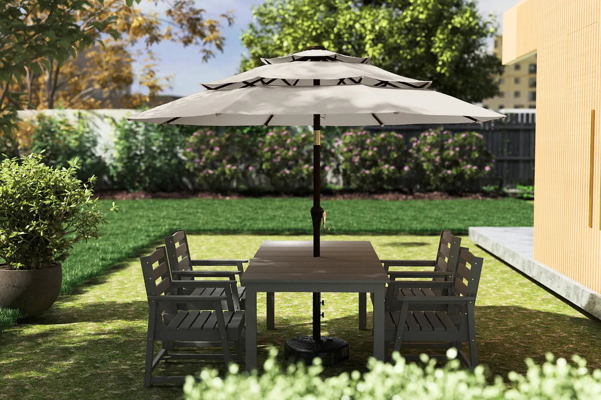 Outdoor patio set with table and chairs under a large umbrella on a grassy area.