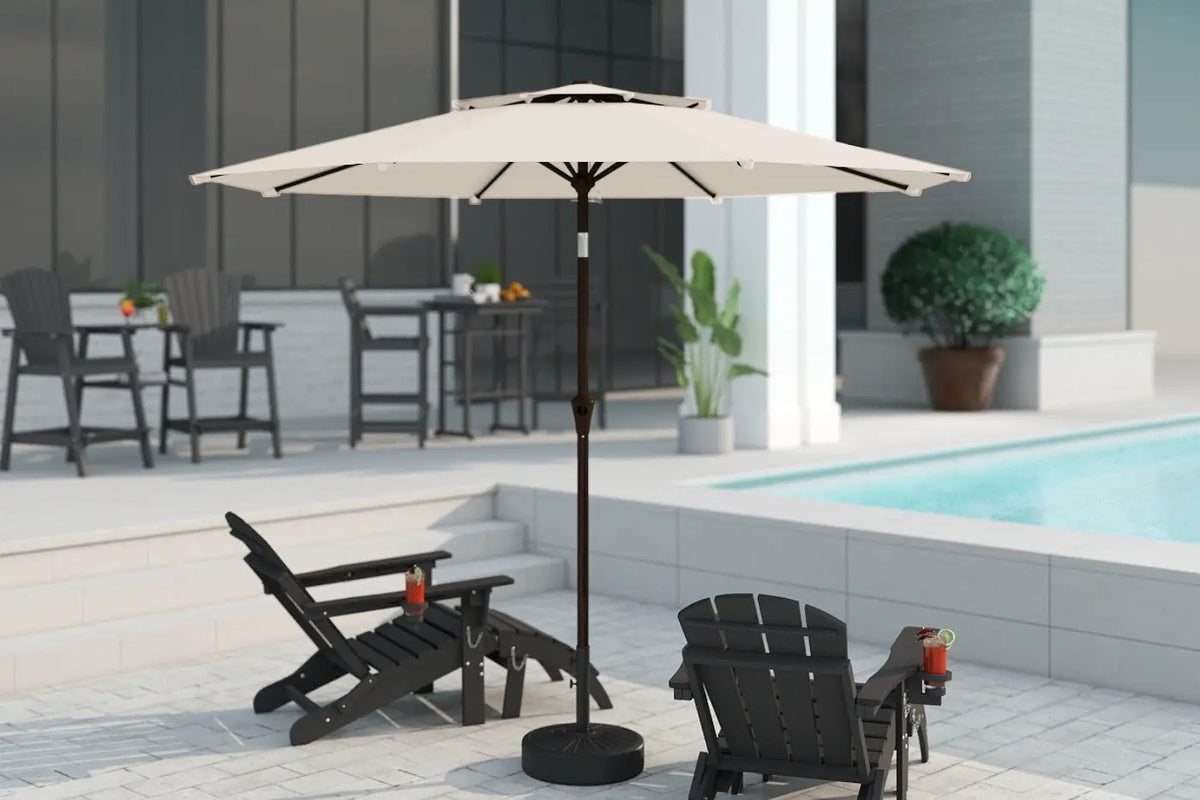 Beige patio umbrella on a stand with lounge chairs and a pool in the background