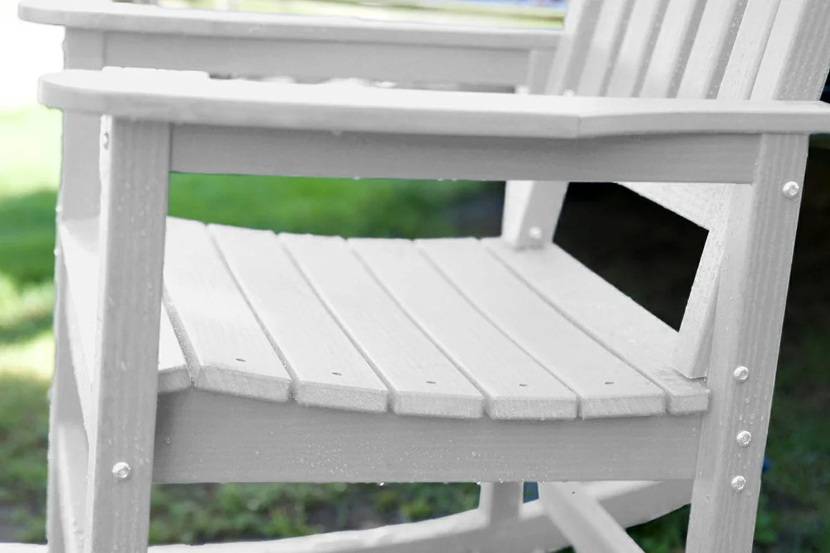 White wooden rocking chair on a blurred green outdoor background