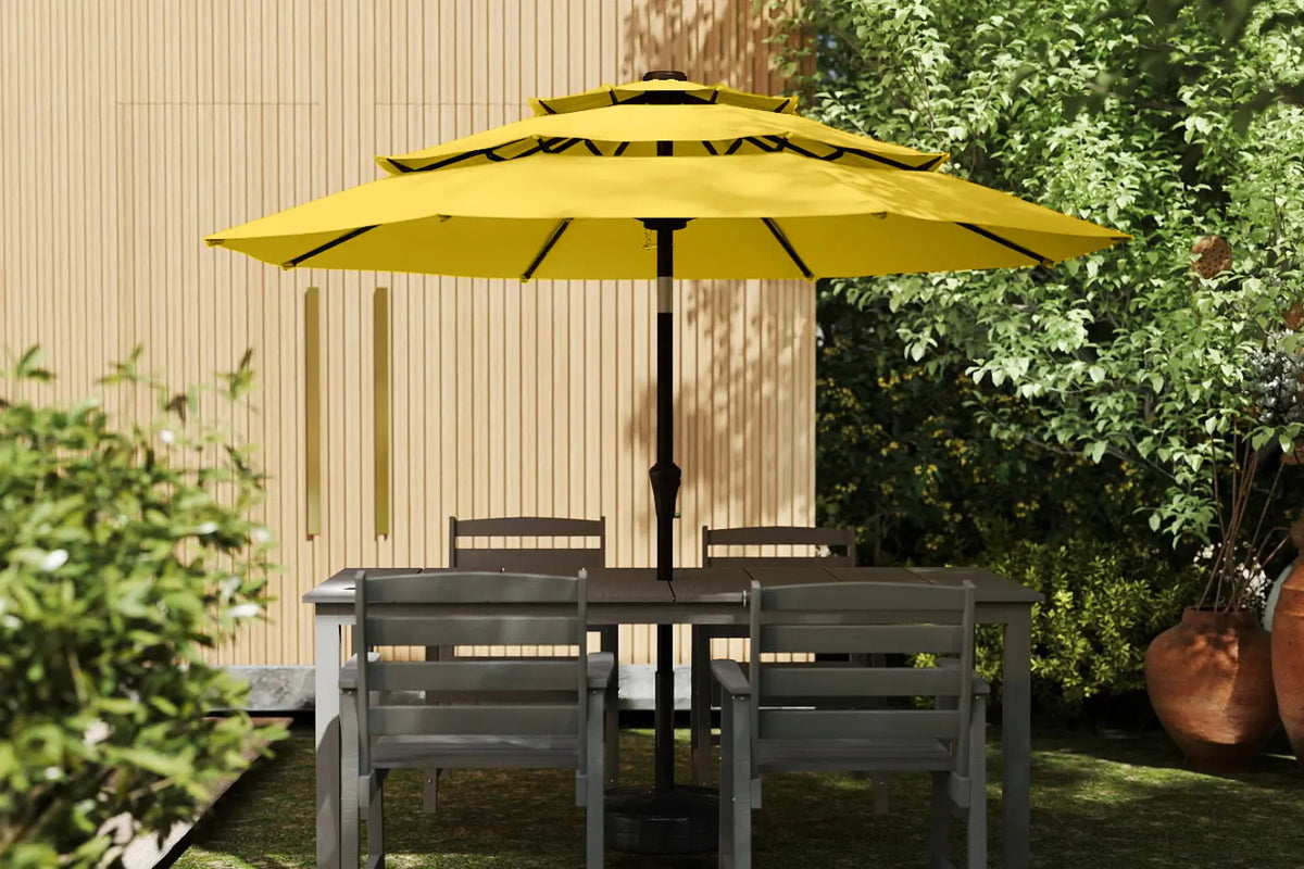 Yellow patio umbrella over a dining table with chairs in a garden setting.