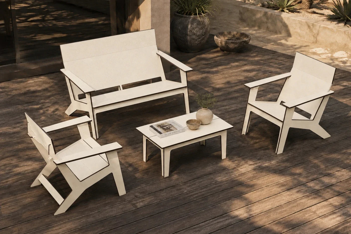 A beige four-piece outdoor patio furniture set including a loveseat, two armchairs, and a small coffee table arranged on a dark wood deck.