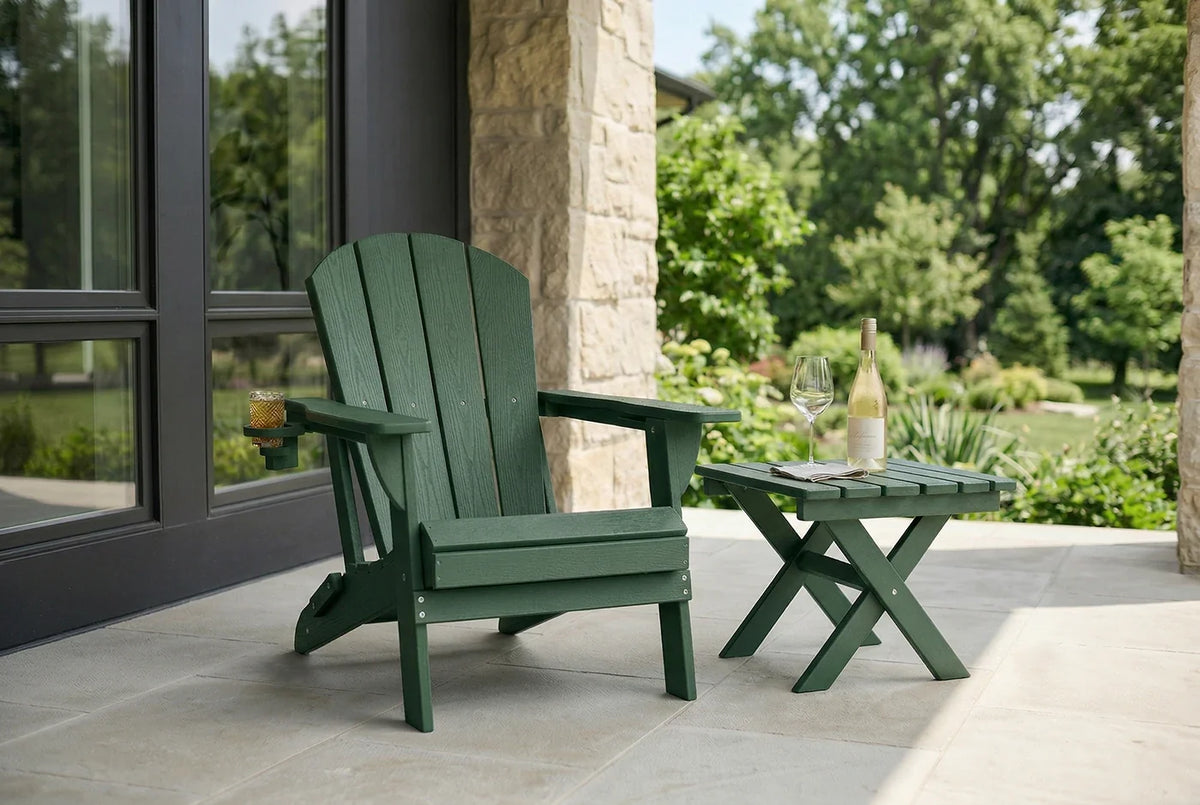 Green Adirondack chair and table on a patio with a view of trees and a building.