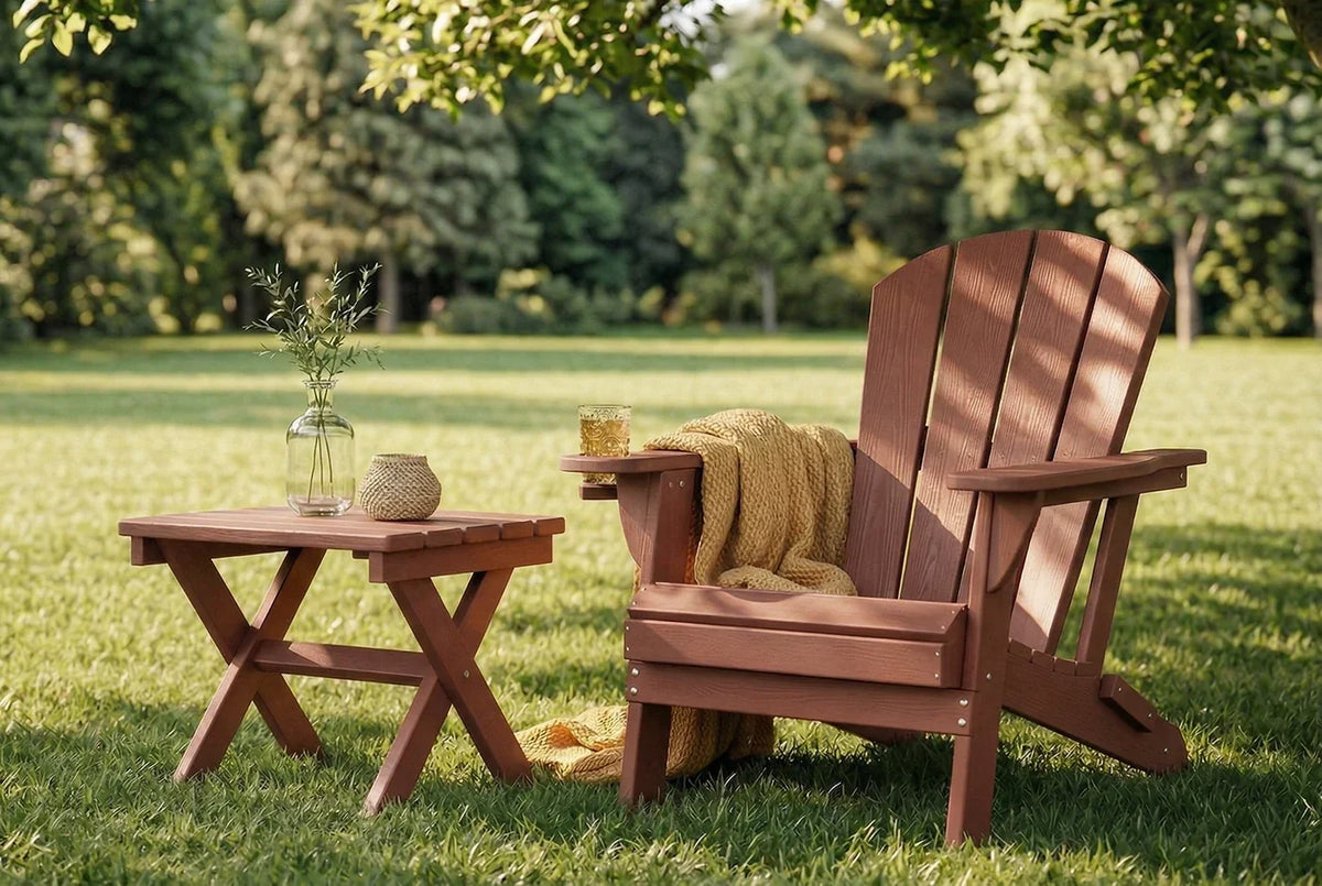 HDPE Adirondack chair with a blanket and small table on a grassy lawn with trees in the background