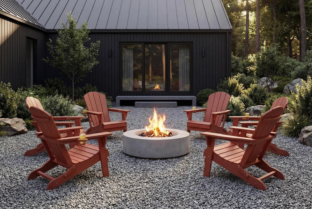 Outdoor setting with red Adirondack chairs around a fire pit in front of a black building.