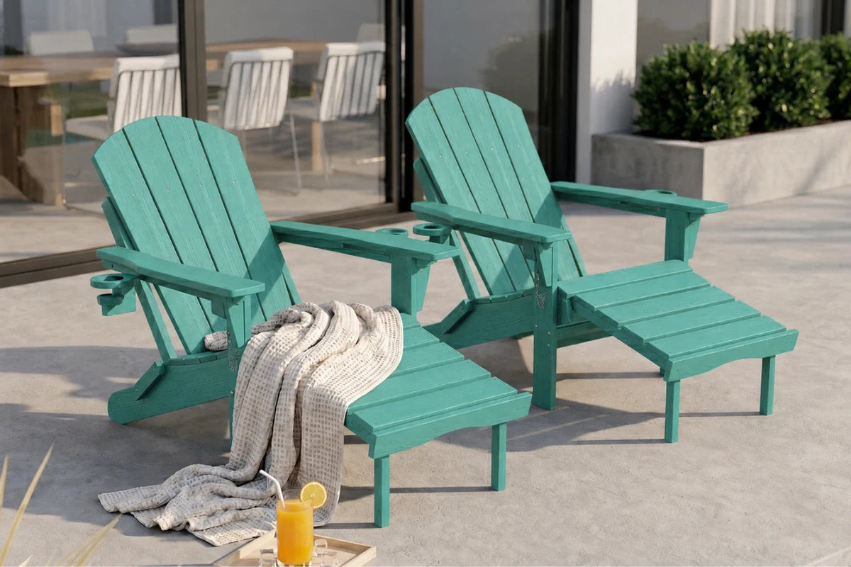 Two aruba blue outdoor Adirondack chairs with matching footrests on a patio, styled with a draped throw blanket and a glass of orange juice.