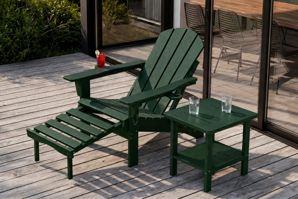 A dark green outdoor Adirondack chair with an attached footrest and a matching side table on a wooden deck, with a glass door and patio furniture visible in the background.