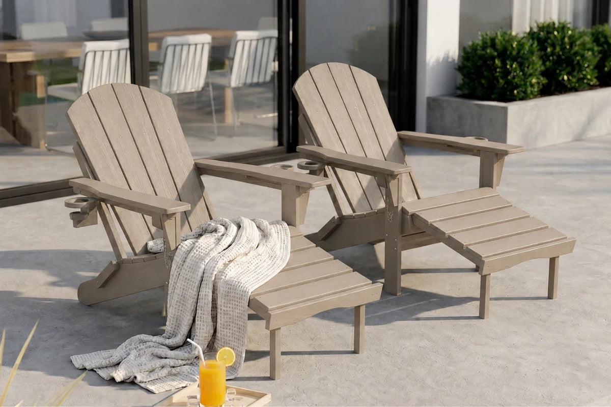 Two light brown HDPE reclining adirondack chair with footrest, set on a concrete patio with a draped throw blanket and a glass of orange juice in the foreground.