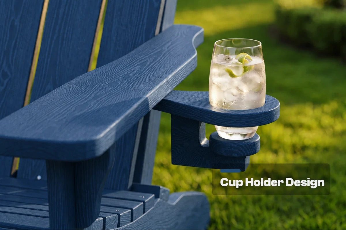 A close-up of a navy blue outdoor Adirondack-style chair arm with a built-in cup holder, holding a clear glass of iced drink with lime slices. The background is blurred green grass, and the text 'Cup Holder Design' appears in the lower right.