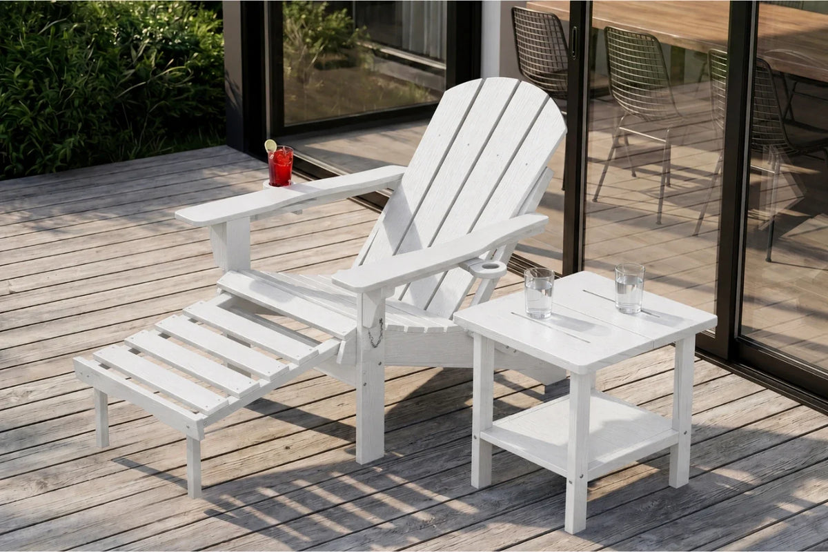 White outdoor patio furniture set including a HDPE reclining adirondack chair with footrest and a matching side table, shown on a wooden deck beside glass doors.