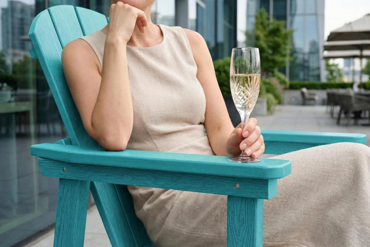 Woman sitting on a aruba blue chair holding a glass of champagne with a cityscape background