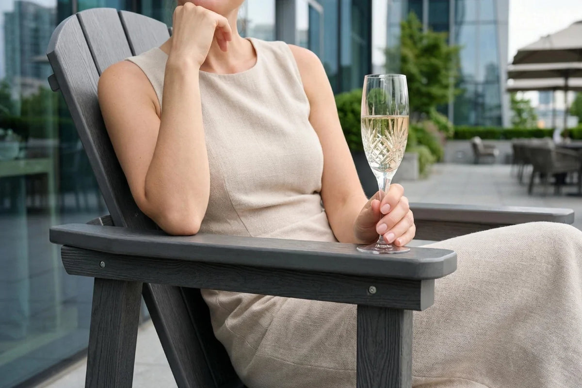 Woman sitting in a gray chair holding a glass of champagne with a cityscape background