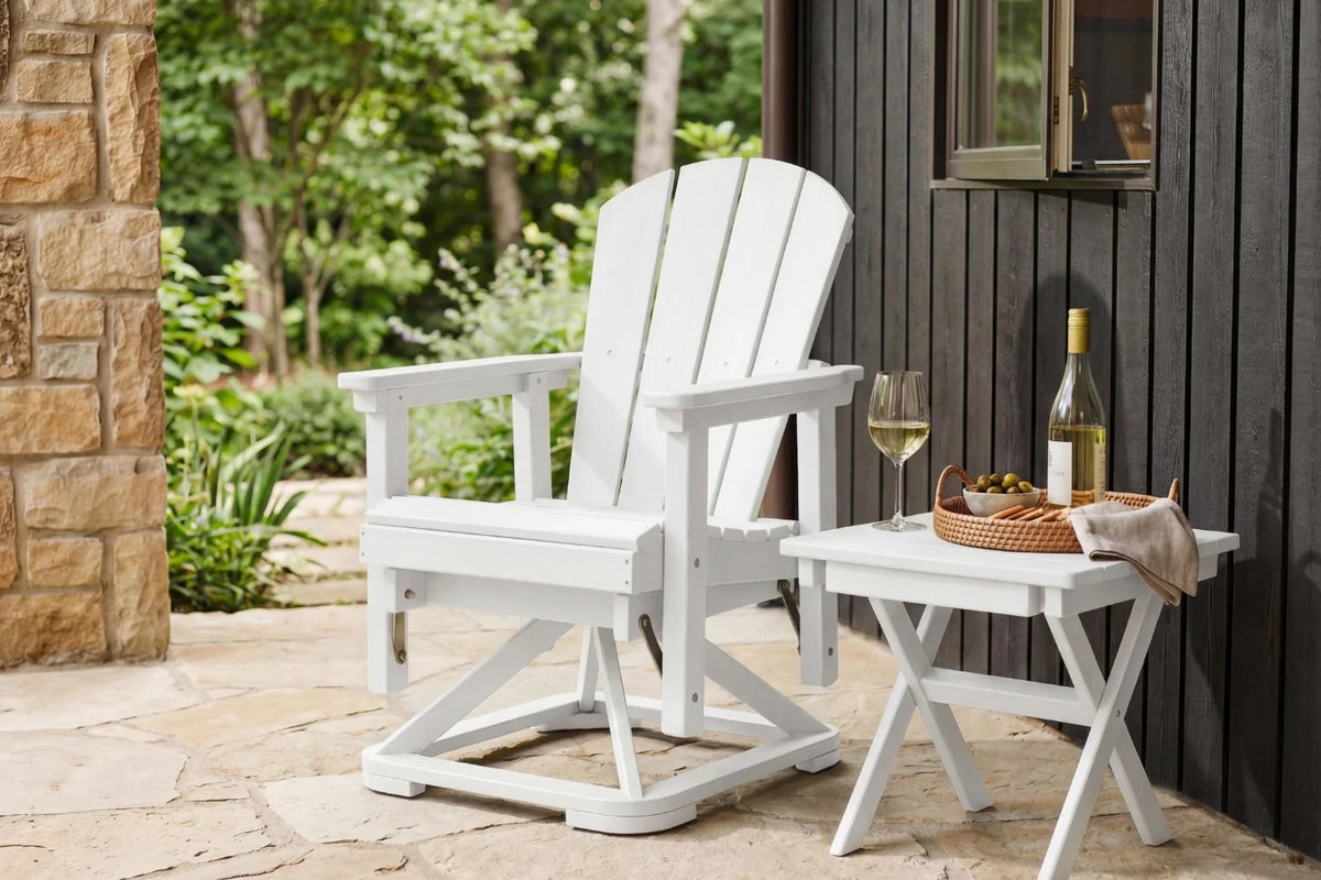 White Adirondack chair and small table on a patio with a bottle of wine and glasses.