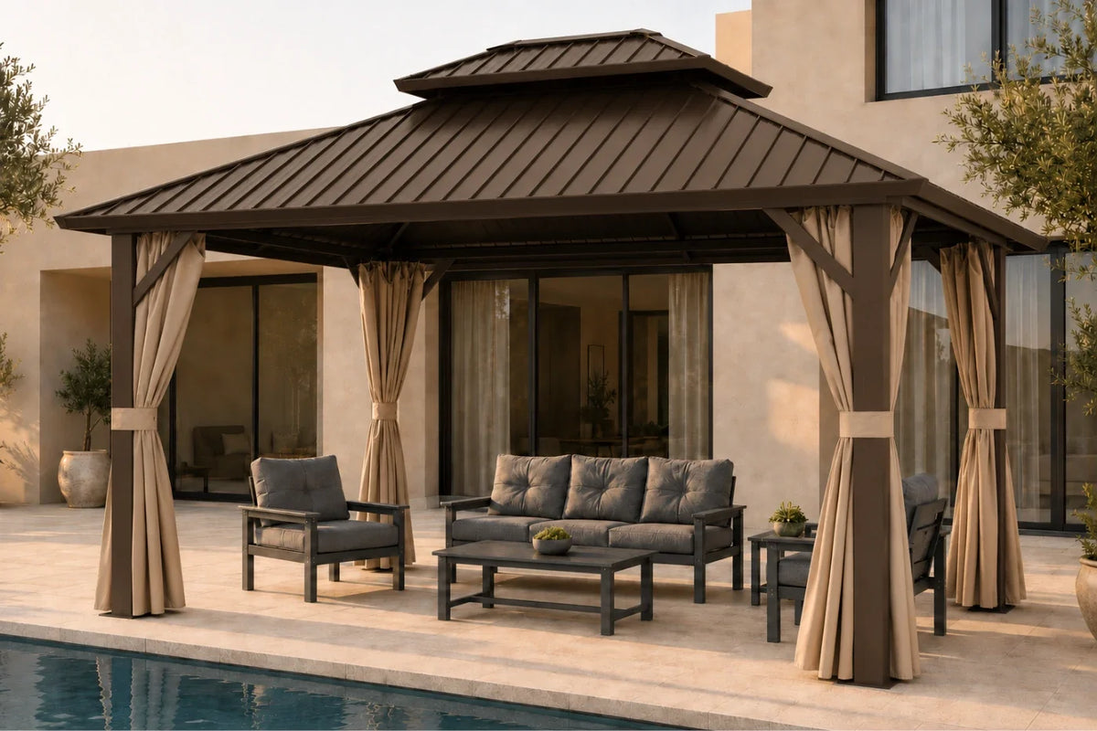 A brown hardtop gazebo with netting and curtains, set on a poolside patio with a matching dark gray outdoor sofa, armchair, and coffee table.