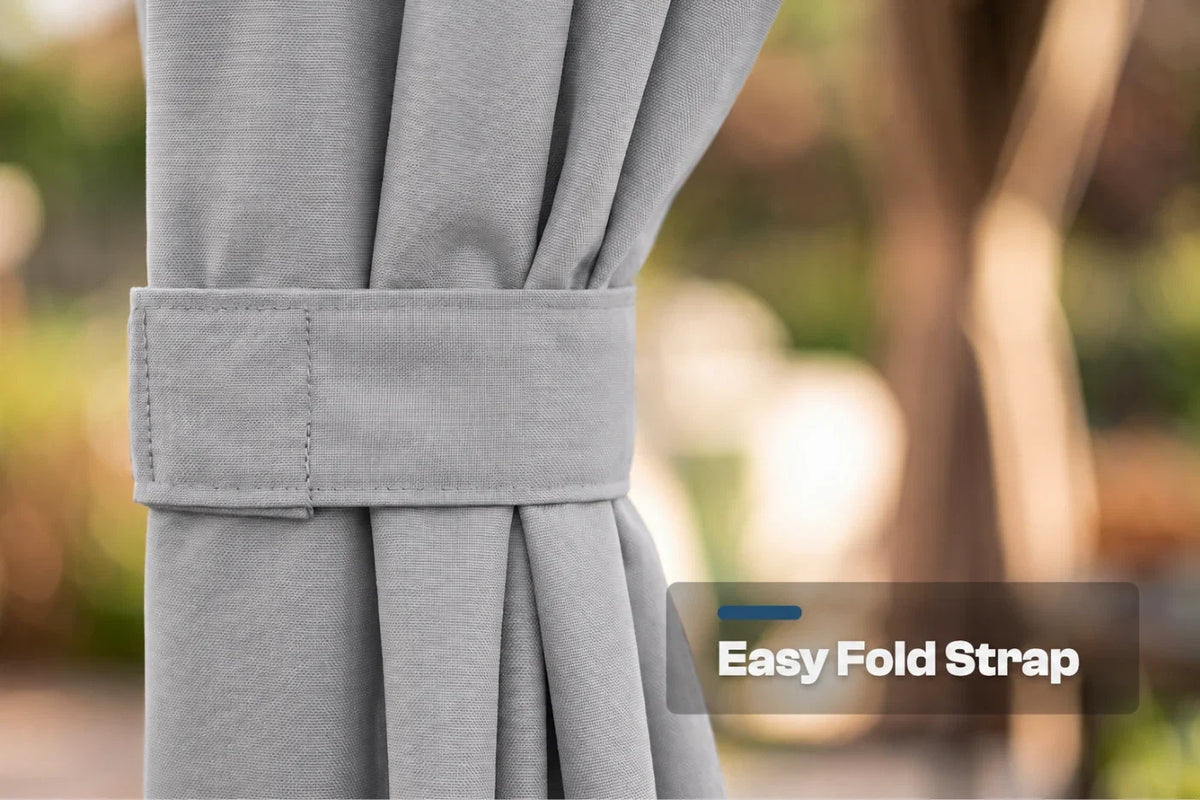 Close-up of a curtain tieback strap holding back pleated fabric, with a blurred outdoor background and a text label reading 'Easy Fold Strap'.