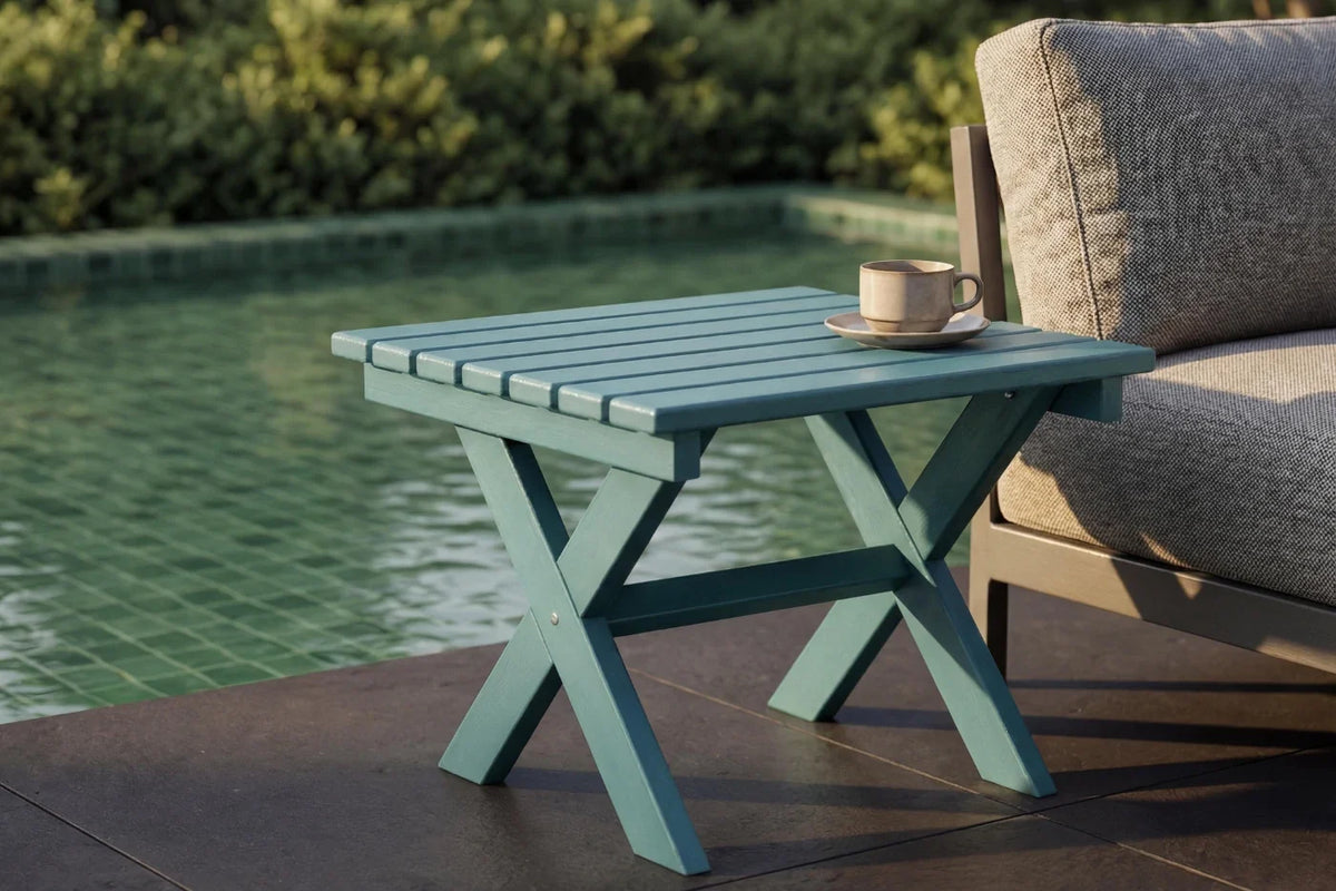 folding table with a cup and saucer on a patio by a pool