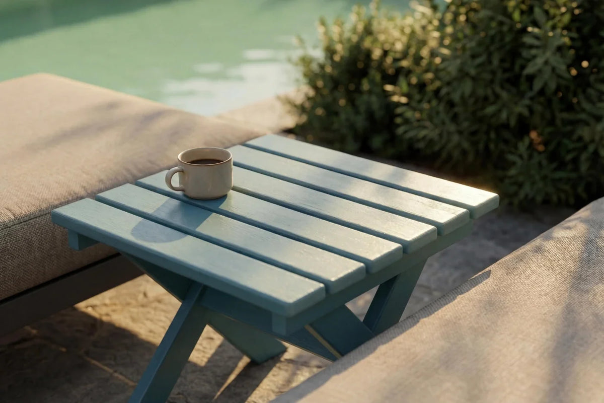 Blue outdoor table with a cup on it by a poolside