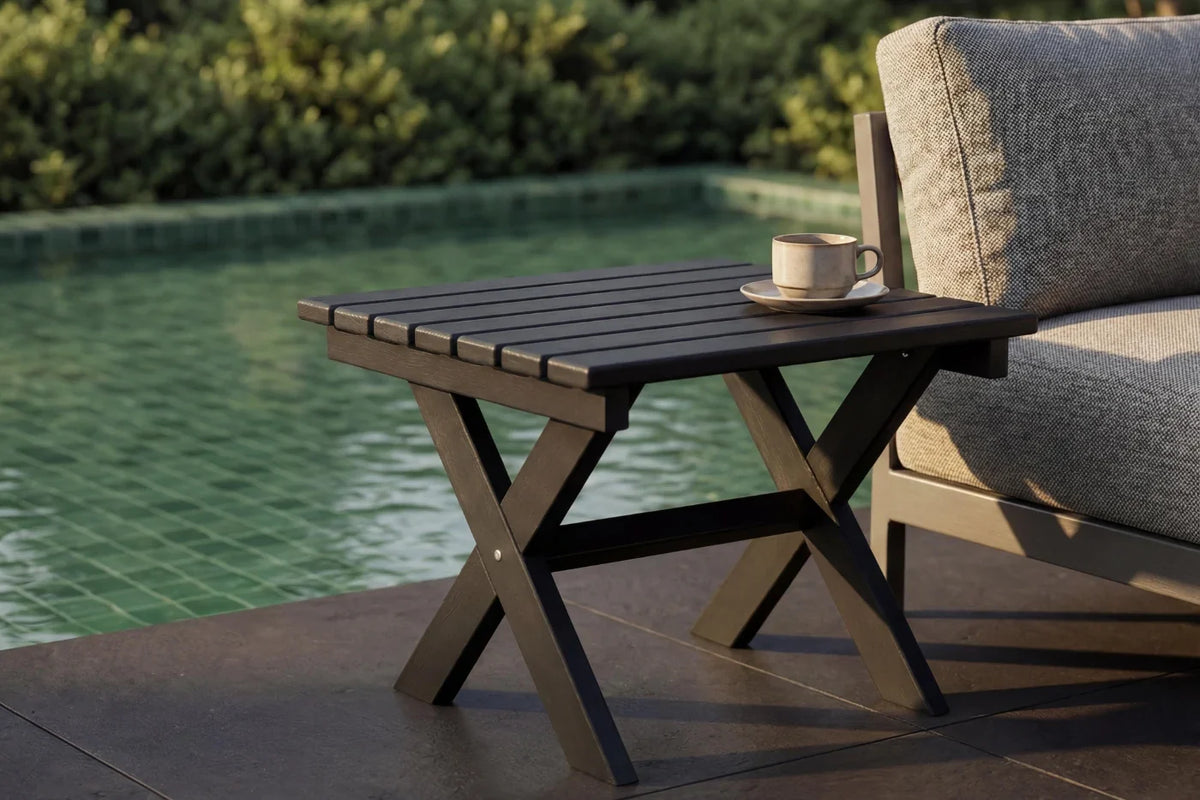 Outdoor setting with a small table by a poolside, featuring a cup and saucer.