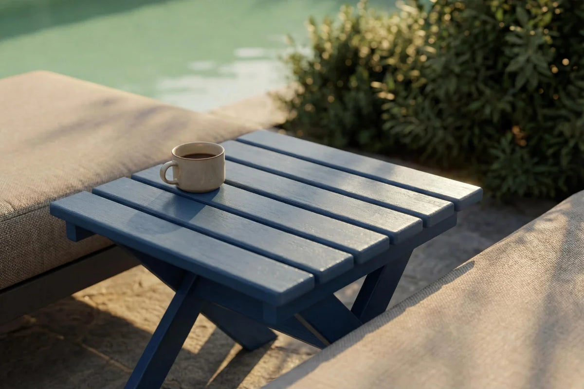 Blue outdoor table with a cup on it, set against a poolside background