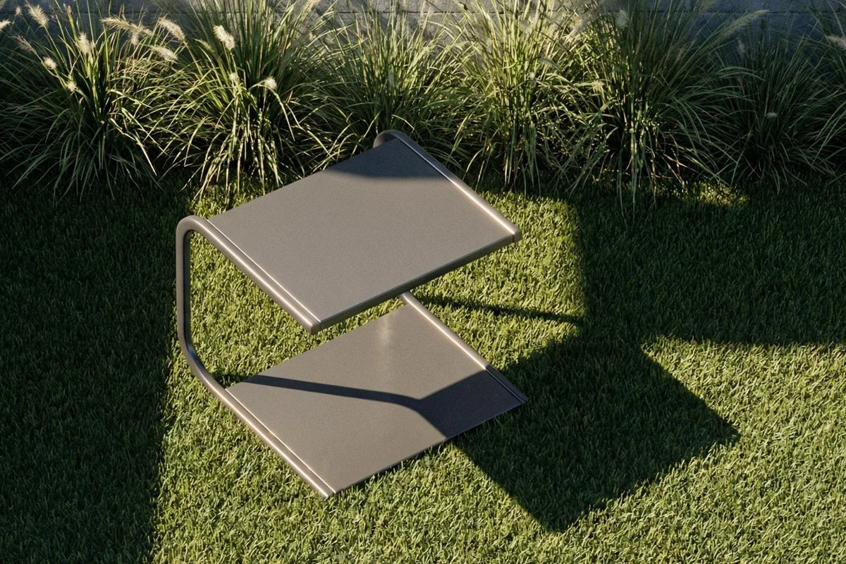 Modern outdoor chair on grass with plants in the background