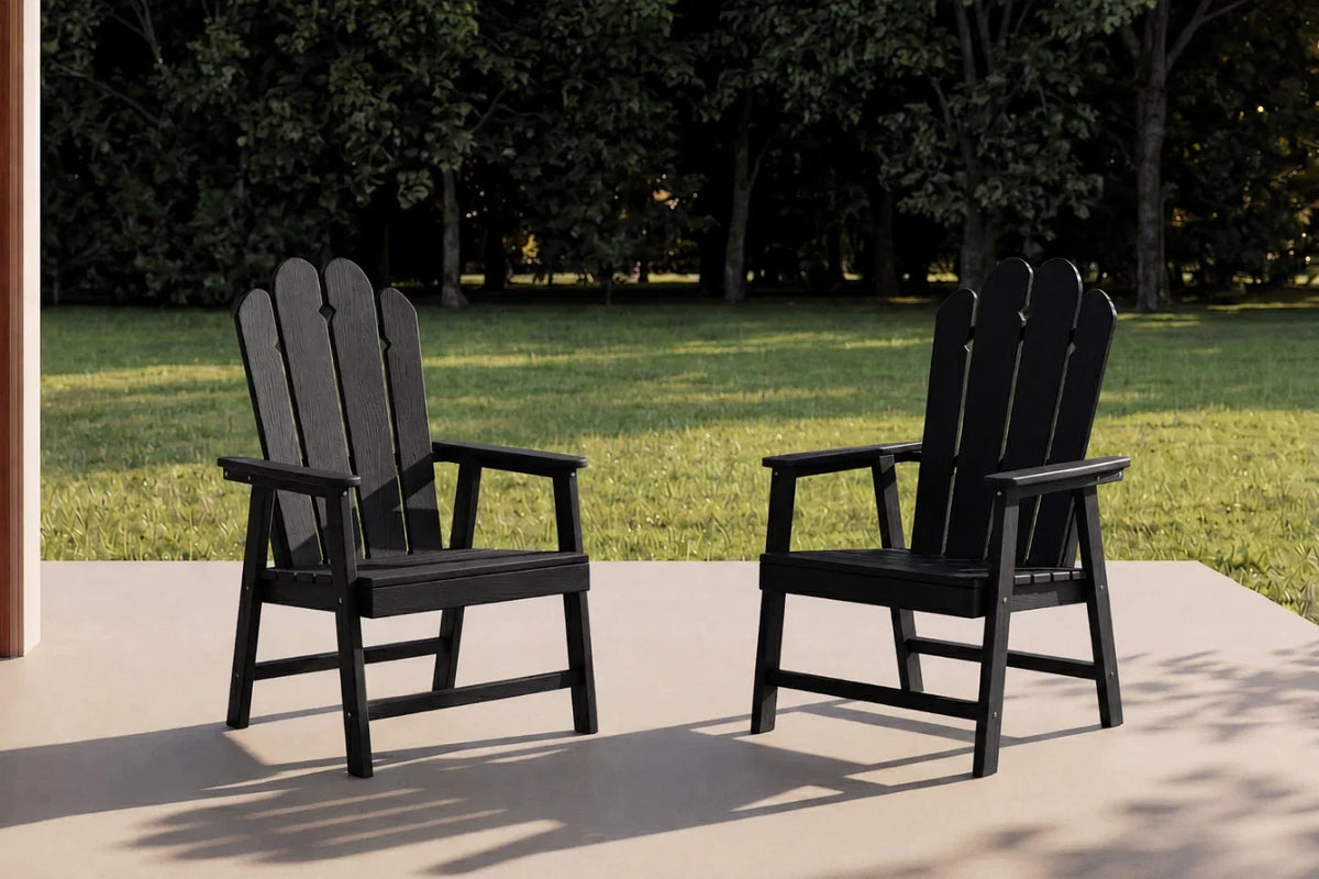 Two black HDPE chairs on a patio with a grassy area and trees in the background.