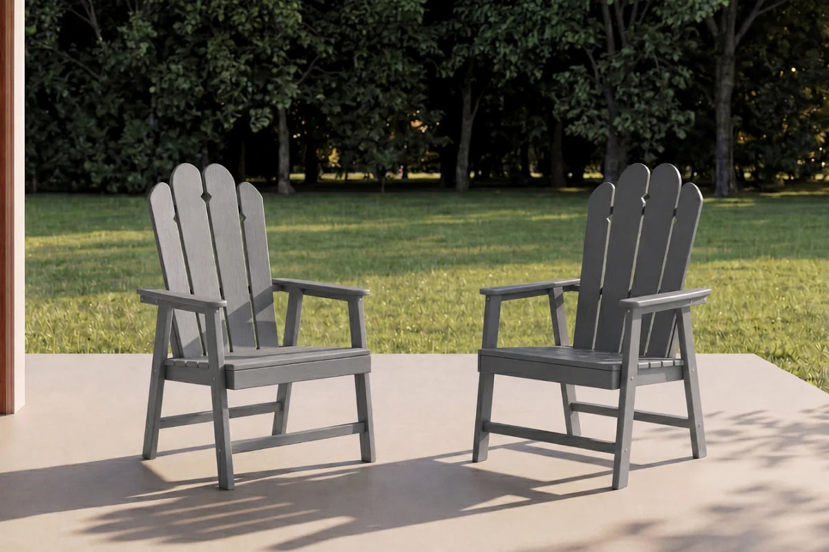 Two dark gray HDPE chairs on a patio with trees in the background