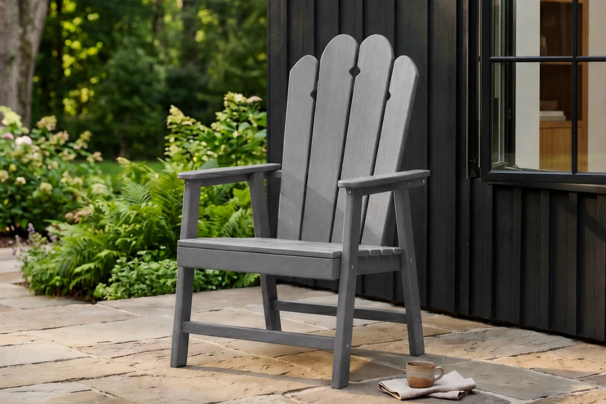 Dark Gray HDPE chair on a patio with greenery and a building in the background