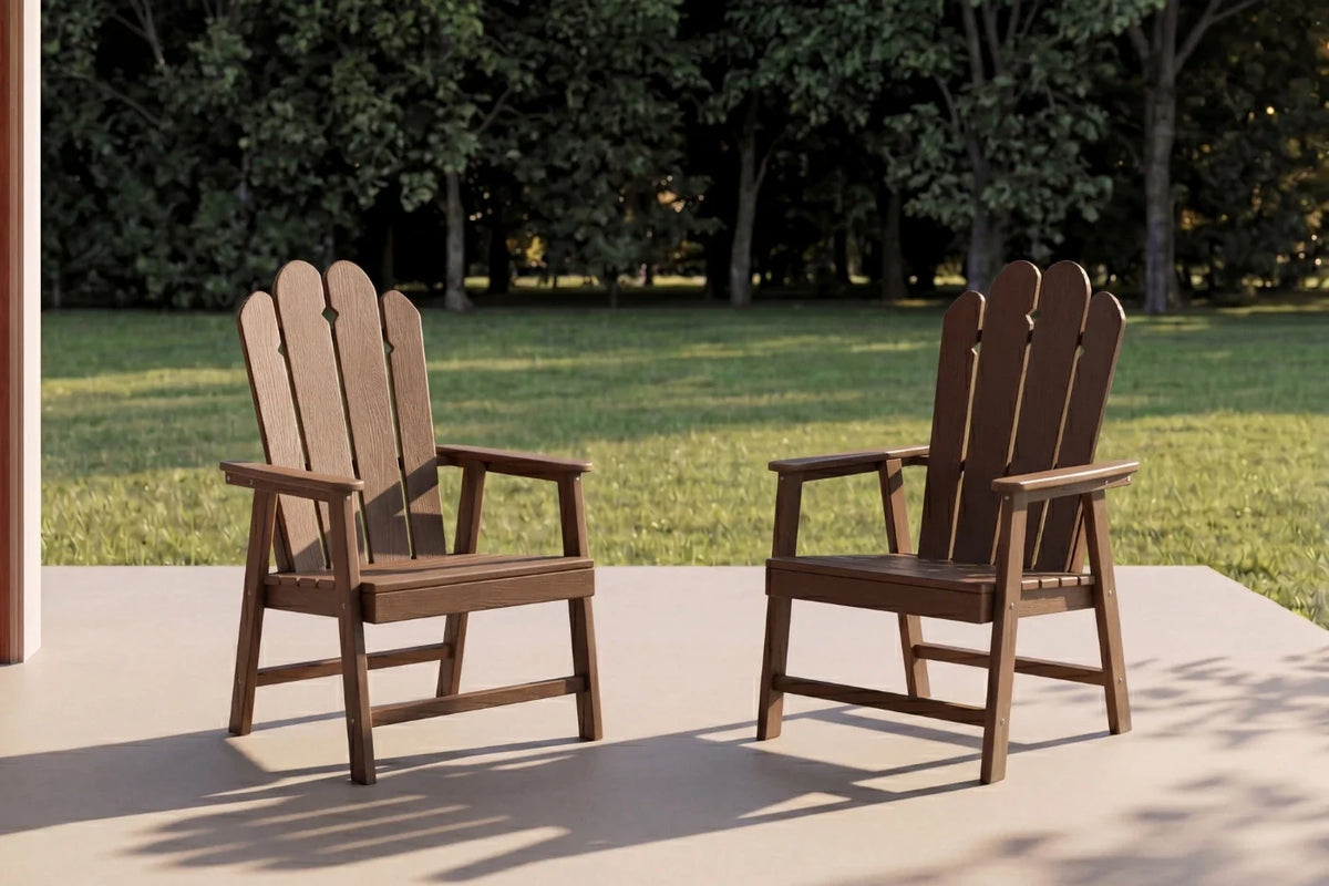 Two light brown Adirondack chairs on a patio with trees in the background