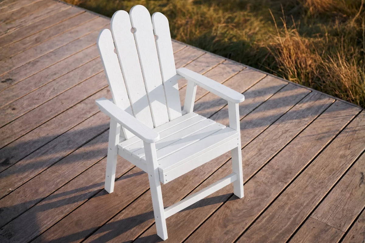 White HDPE chair on a wooden deck with grass in the background
