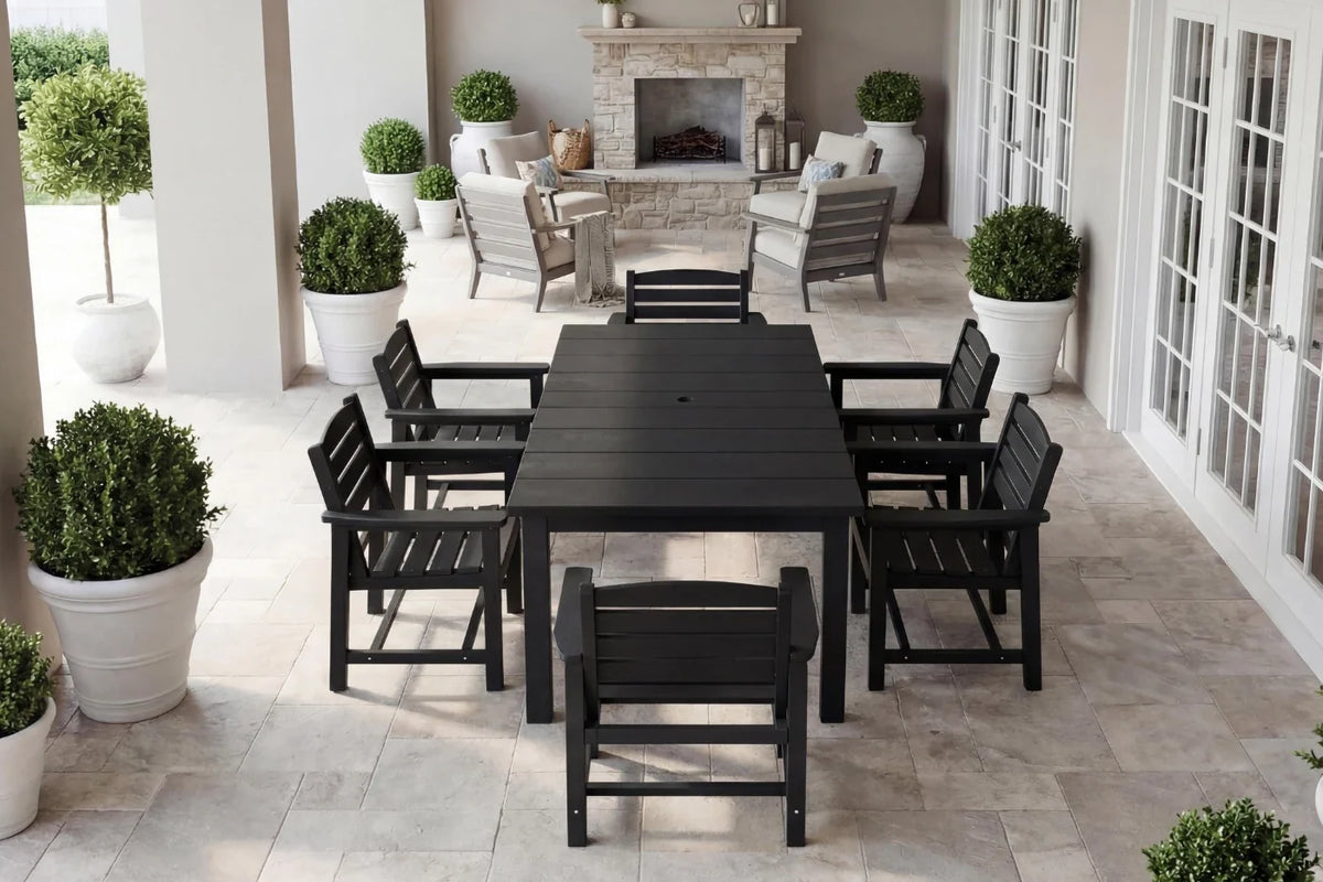 Outdoor patio set with black table and chairs on a stone patio.