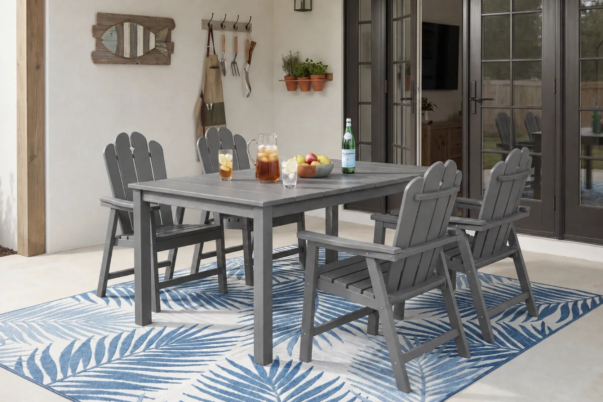 Outdoor dining area with dark gray table and chairs on a blue and white patterned rug.