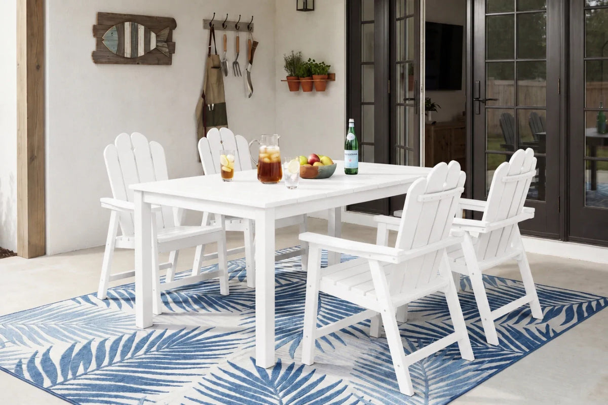 White outdoor dining set with table and 4 chairs on a blue and white patterned rug.
