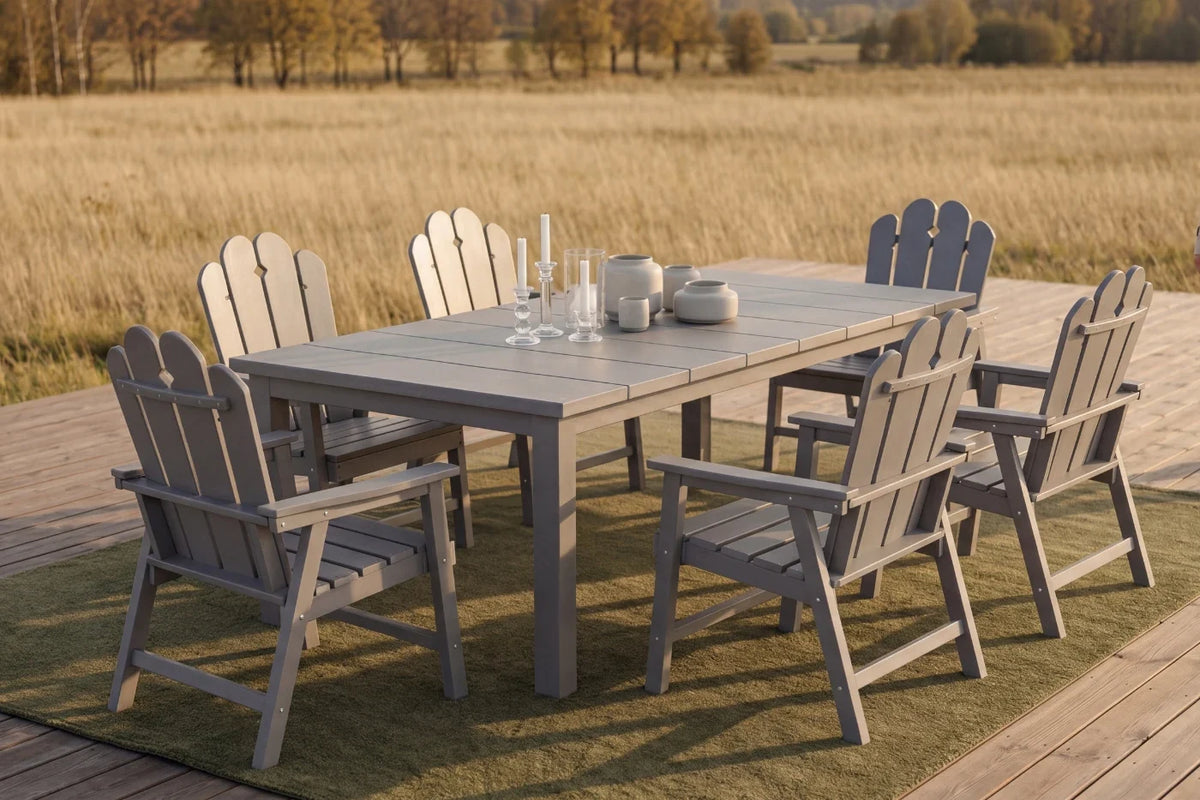 Gray Outdoor dining set with a table and chairs on a deck overlooking a field.