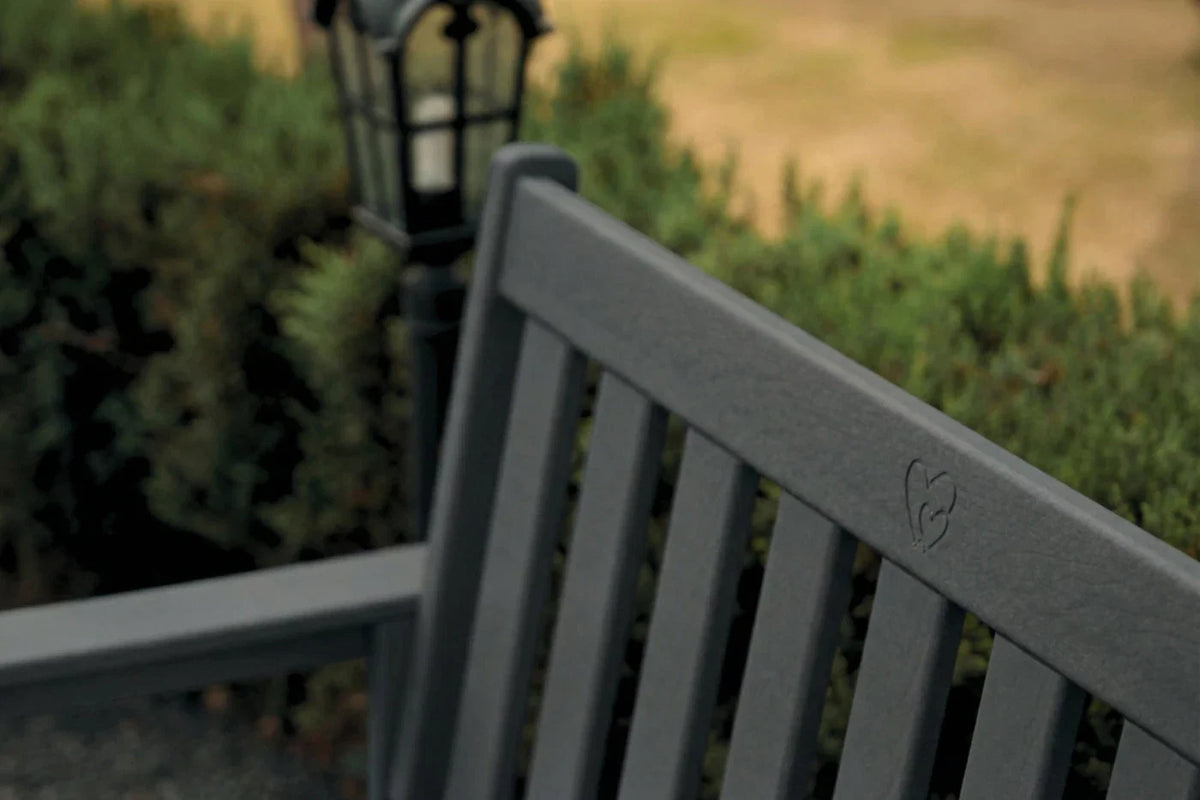 Gray bench with a blurred background of greenery and a lamp post
