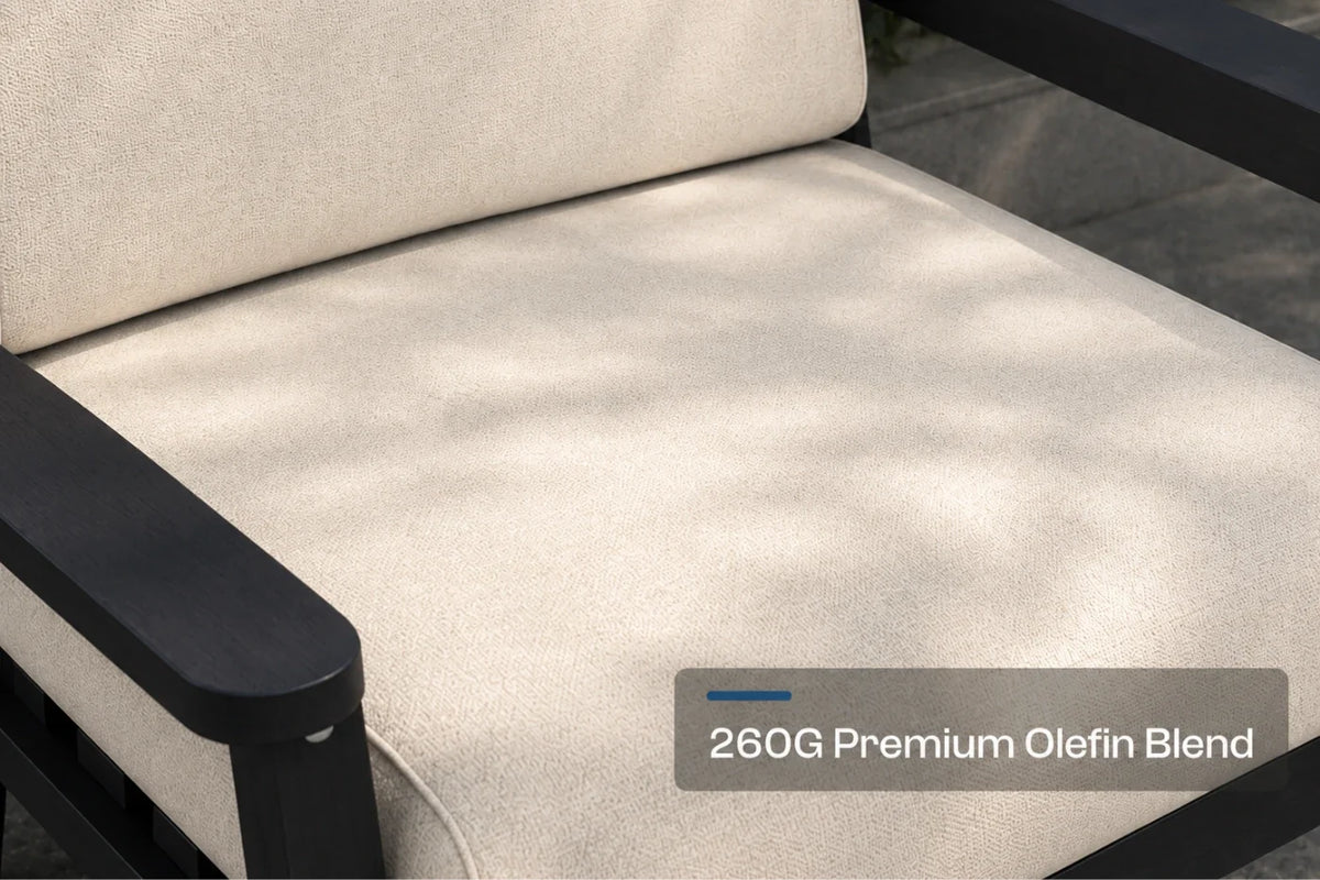 Close-up of a patio chair cushion in a creamy white fabric with a black frame, featuring a text overlay that reads '260G Premium Olefin Blend'.
