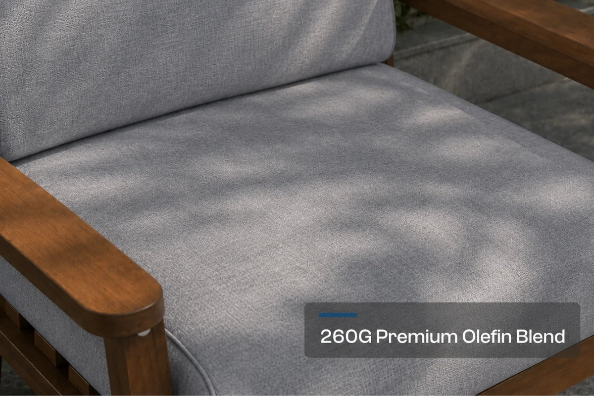 Close-up of a gray outdoor chair cushion with a brown frame, showing dappled sunlight and a text overlay that reads '260G Premium Olefin Blend'.