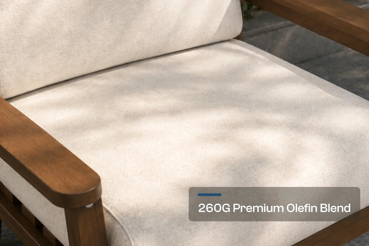Close-up of a creamy white outdoor chair cushion on a HDPE armchair, with dappled sunlight and a text overlay reading '260G Premium Olefin Blend'.
